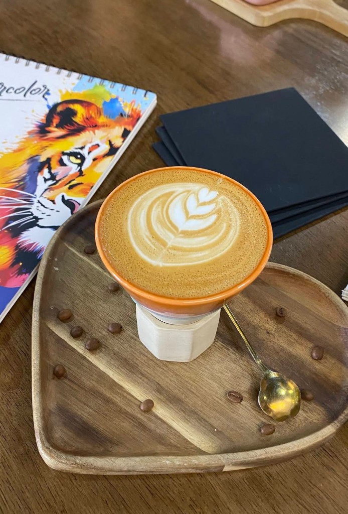 Signature latte in orange cup on heart-shaped tray