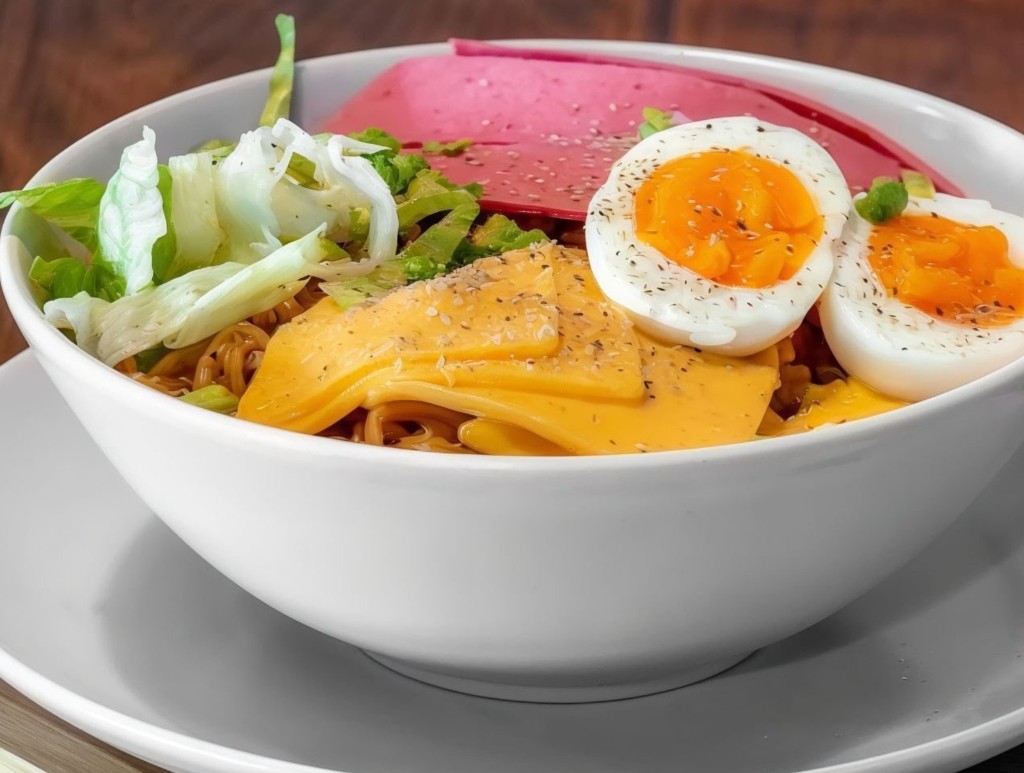 Ramen bowl with soft-boiled egg, cheddar, and greens