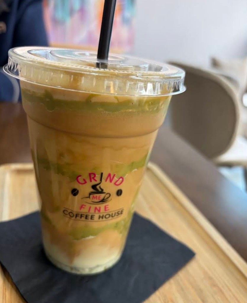 Layered matcha iced coffee in Grind Me Fine branded cup